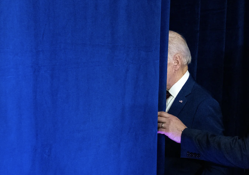 President Biden exiting behind a blue curtain