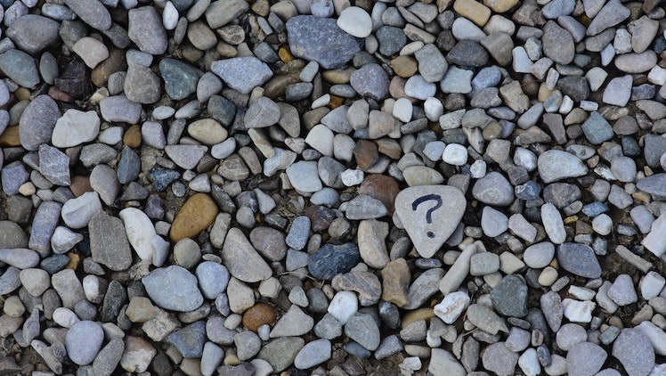 One rock in a sea of rocks has a question mark painted on it.